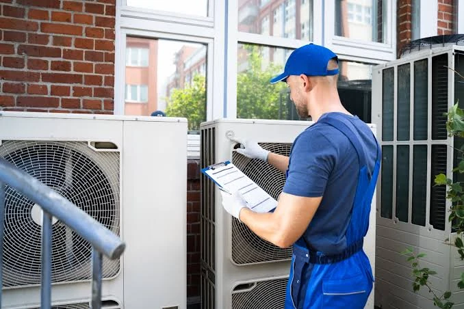 Technician inspecting outdoor air-conditioning equipment with a checklist